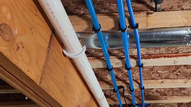 Blue PEX supply lines clipped along floor joists beside a white pipe
