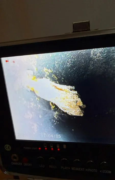 Camera monitor showing a pipe interior with debris and a recording timer