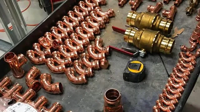 Tray of copper elbows and couplings with two brass ball valves and a tape measure