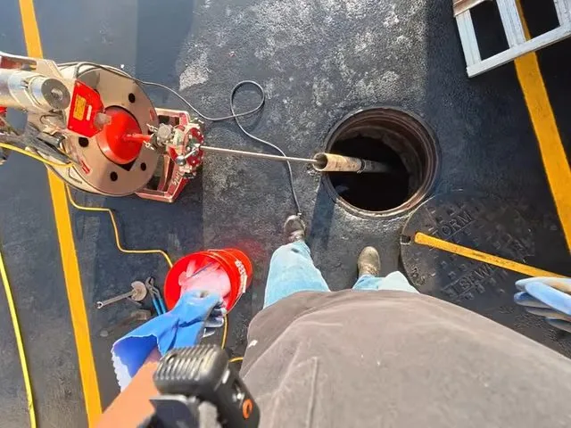 First-person view of a drain machine cable at an open floor drain