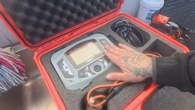 Gloved hand on a camera controller with a cable sitting in an open orange case